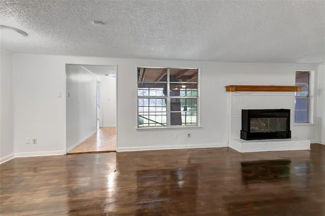a living room with wooden floor and a fireplace