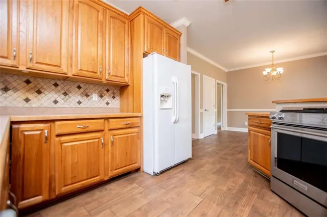 a view of a kitchen with a stove cabinets a ceiling fan and wooden floor