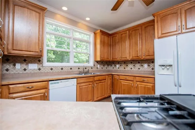 a view of an empty room with window and a ceiling fan