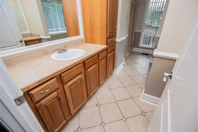 an empty room with wooden floor cabinet and windows