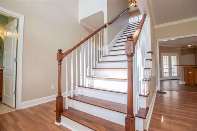 a view of an empty room with wooden floor and a ceiling fan