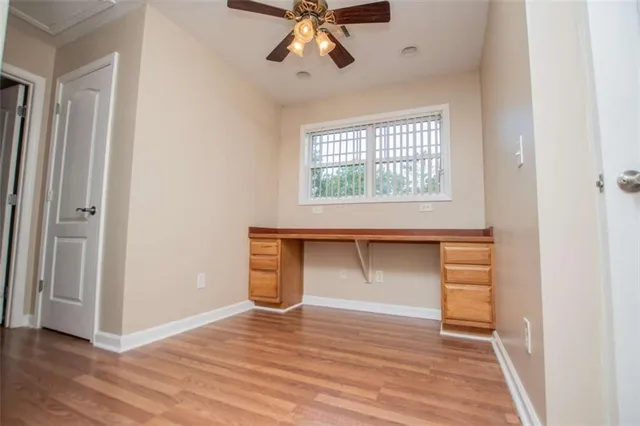 a view of an empty room with wooden floor and a hallway
