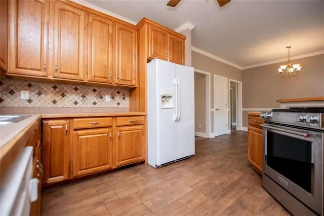 a kitchen with stainless steel appliances granite countertop a stove a sink dishwasher and a refrigerator