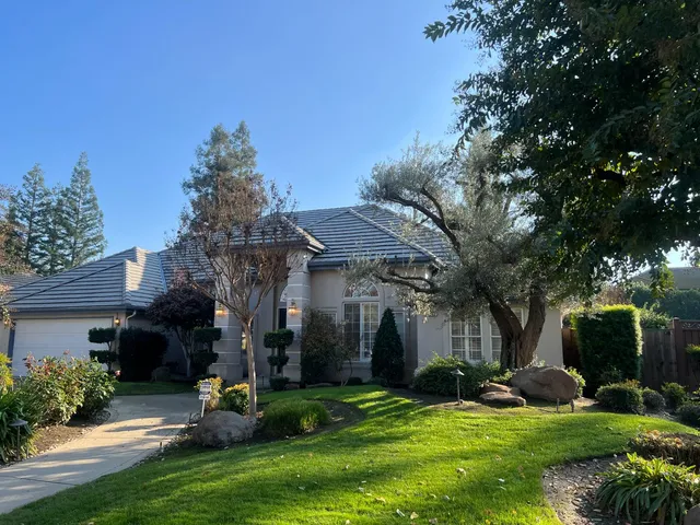 a view of a house with backyard and sitting area