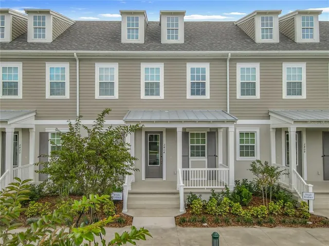 a front view of a house with plants and entryway