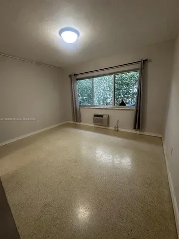 an empty room with a fireplace and windows