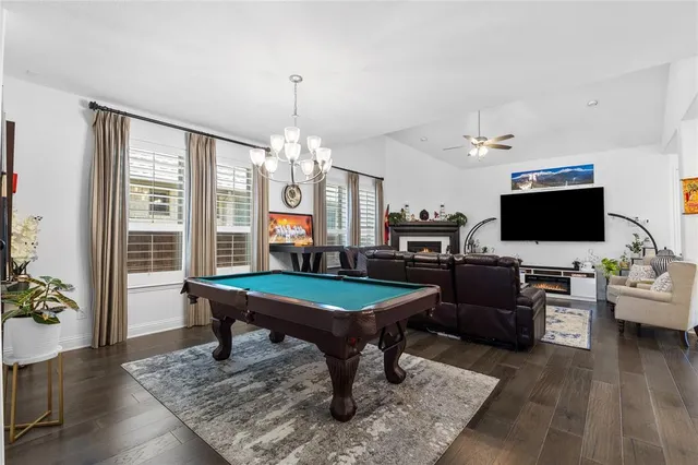 a room with furniture pool table flat screen tv and windows