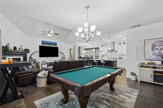 a living room with furniture a flat screen tv and kitchen view