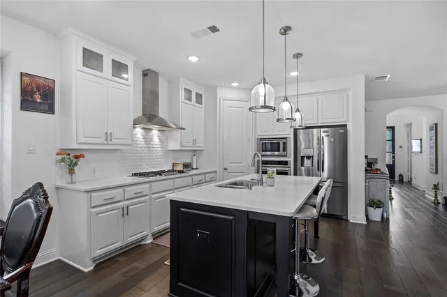 a view of a dining room kitchen island with wooden floor and chandelier