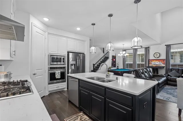 a kitchen with stainless steel appliances granite countertop a sink and a stove