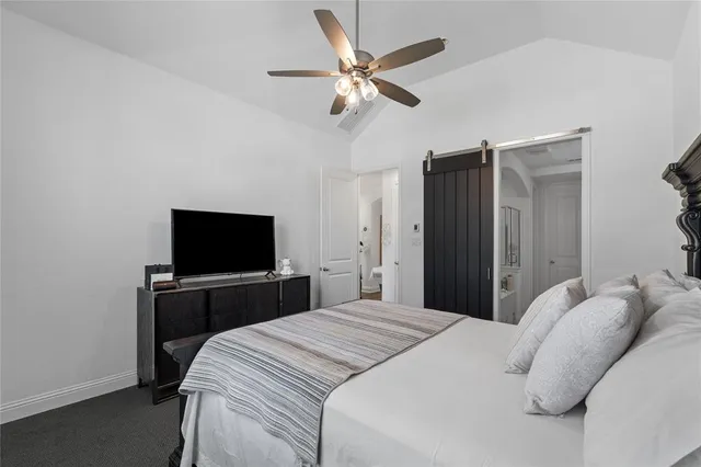 a bedroom with a bed and a flat tv screen on dresser