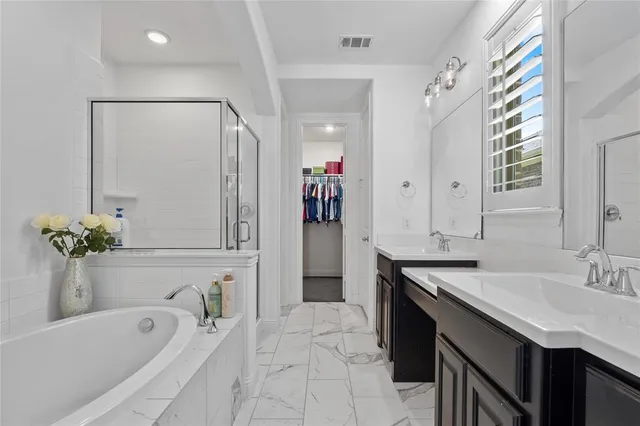 a bathroom with a tub sink and mirror