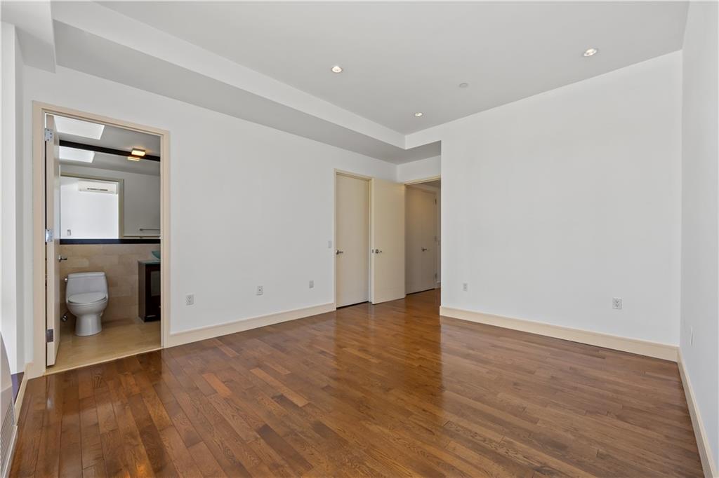 71 Village Road North, Unit 3E Brooklyn, NY 11223 - Photo 12 of 20 a view of an empty room with wooden floor and a sink