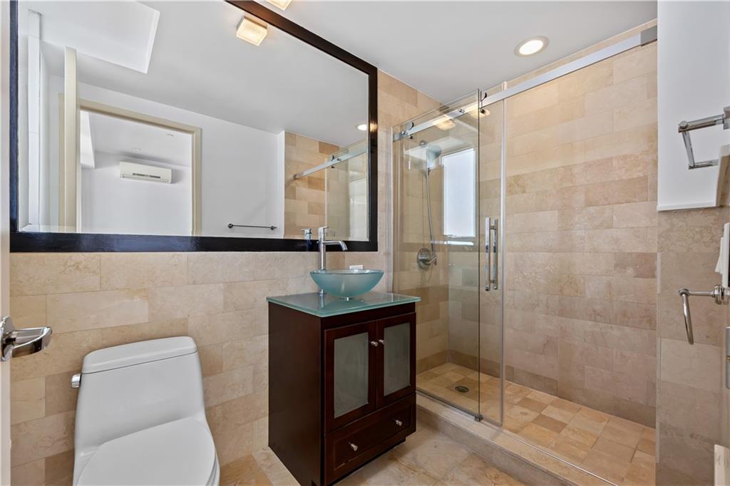 71 Village Road North, Unit 3E Brooklyn, NY 11223 - Photo 13 of 20 a bathroom with a toilet a sink a mirror and shower
