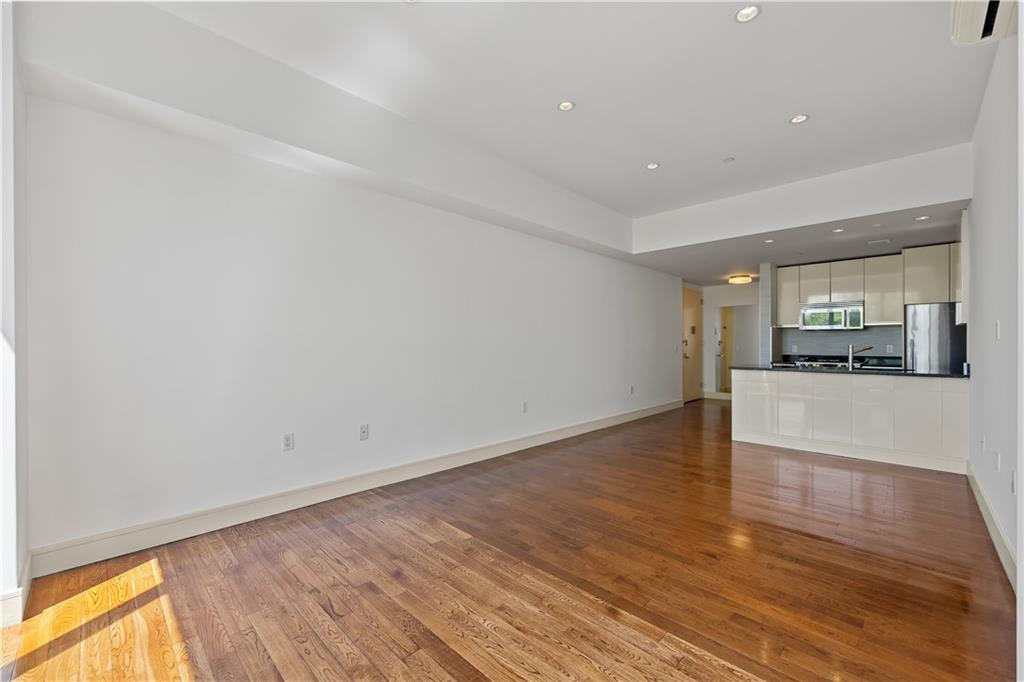 71 Village Road North, Unit 3E Brooklyn, NY 11223 - Photo 4 of 20 a view of empty room with wooden floor and fireplace