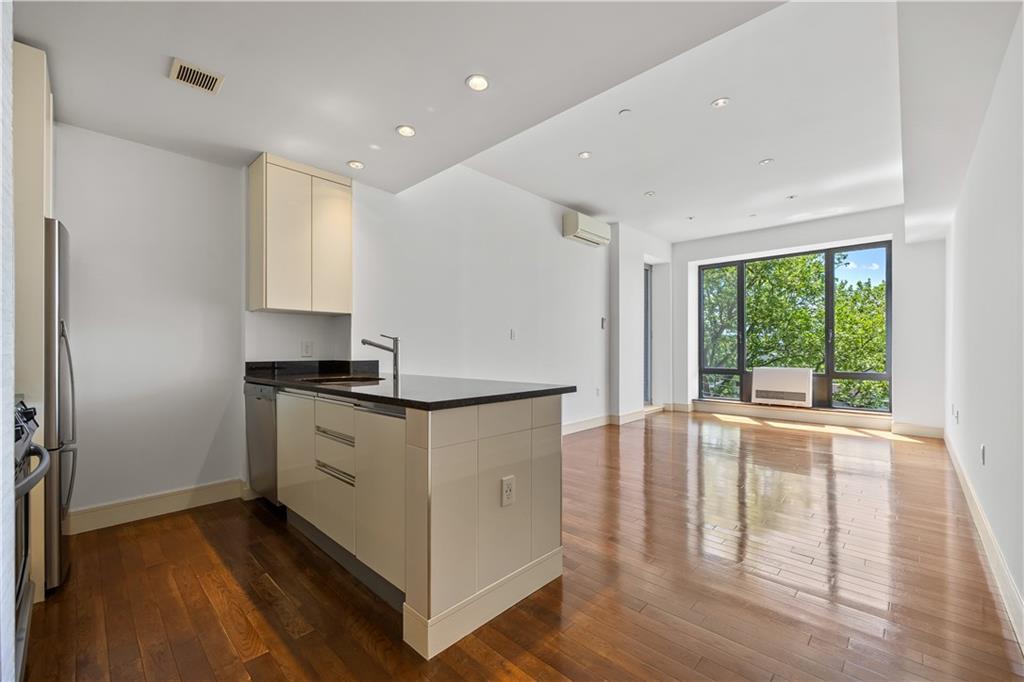 71 Village Road North, Unit 3E Brooklyn, NY 11223 - Photo 5 of 20 a kitchen with stainless steel appliances granite countertop a stove and a large window