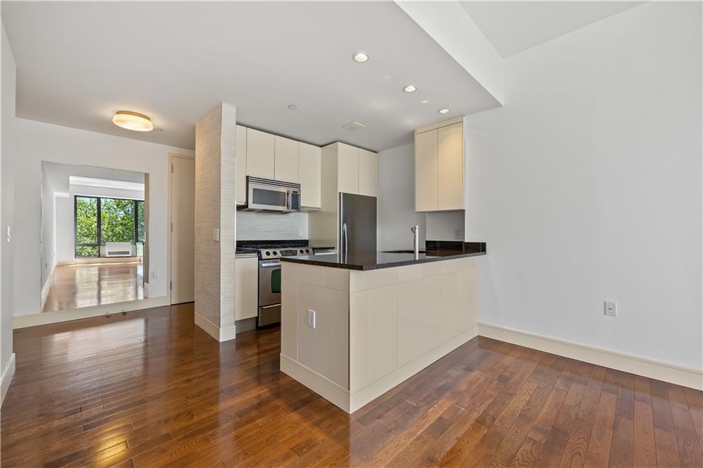 71 Village Road North, Unit 3E Brooklyn, NY 11223 - Photo 6 of 20 a living room with stainless steel appliances kitchen island hardwood floor and window