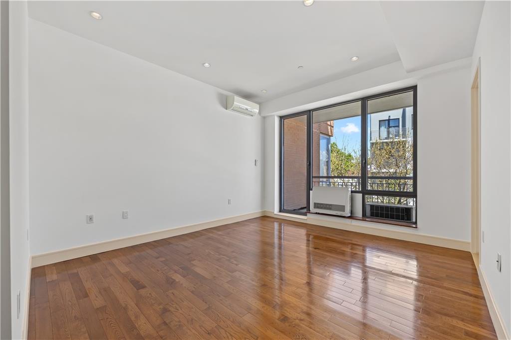 71 Village Road North, Unit 3E Brooklyn, NY 11223 - Photo 8 of 20 wooden floor in an empty room with a window