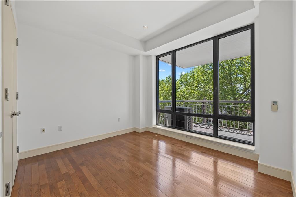 71 Village Road North, Unit 3E Brooklyn, NY 11223 - Photo 9 of 20 a view of an empty room with wooden floor and a window