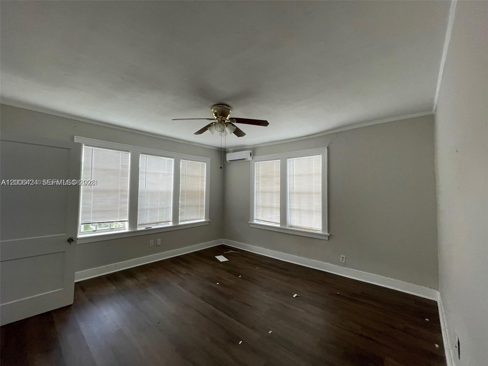 3364 Southwest 2nd Street, Unit 4 Miami, FL 33135 - Photo 6 of 14 an empty room with wooden floor and windows