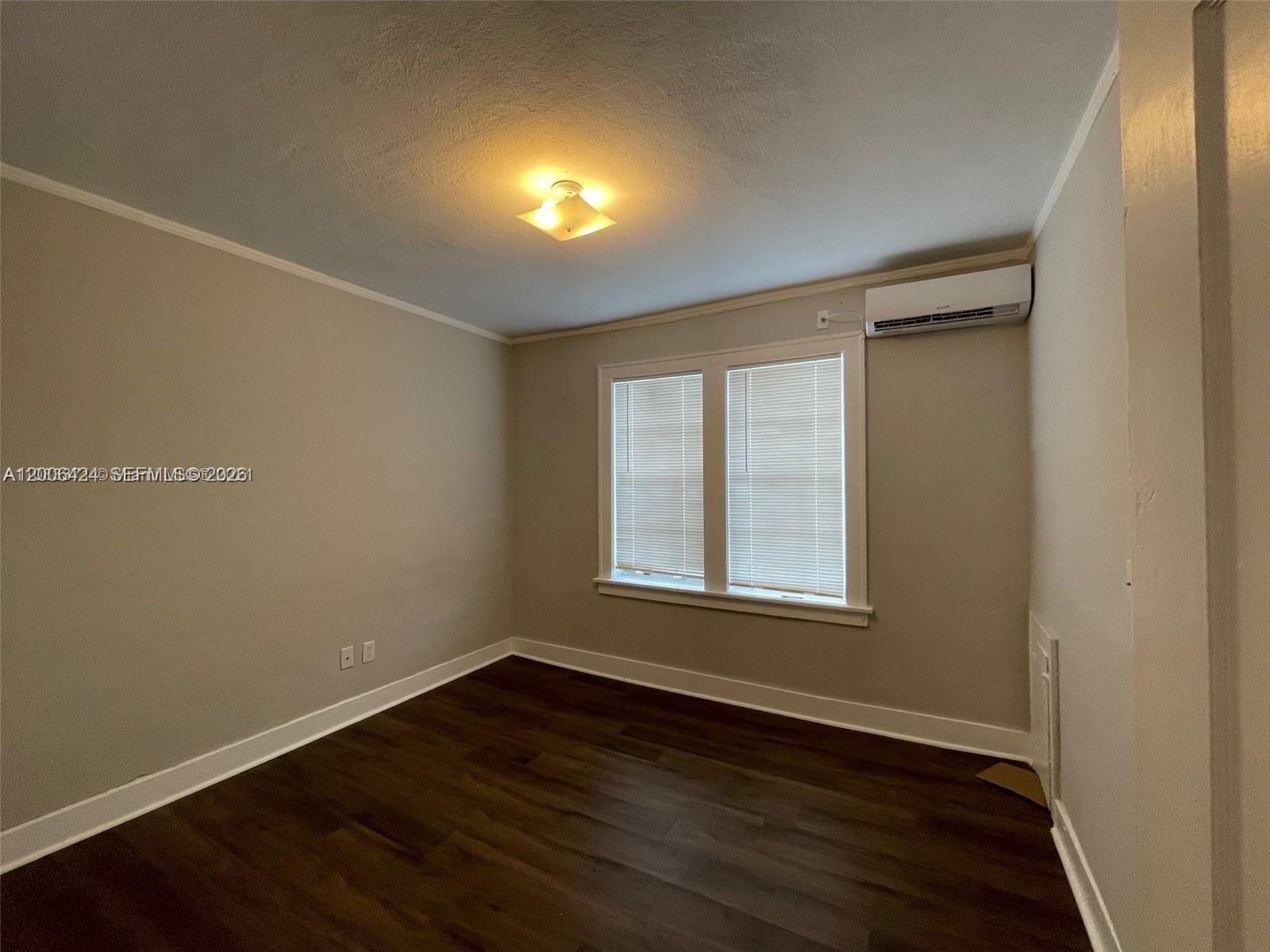 3364 Southwest 2nd Street, Unit 4 Miami, FL 33135 - Photo 8 of 14 an empty room with wooden floor and windows