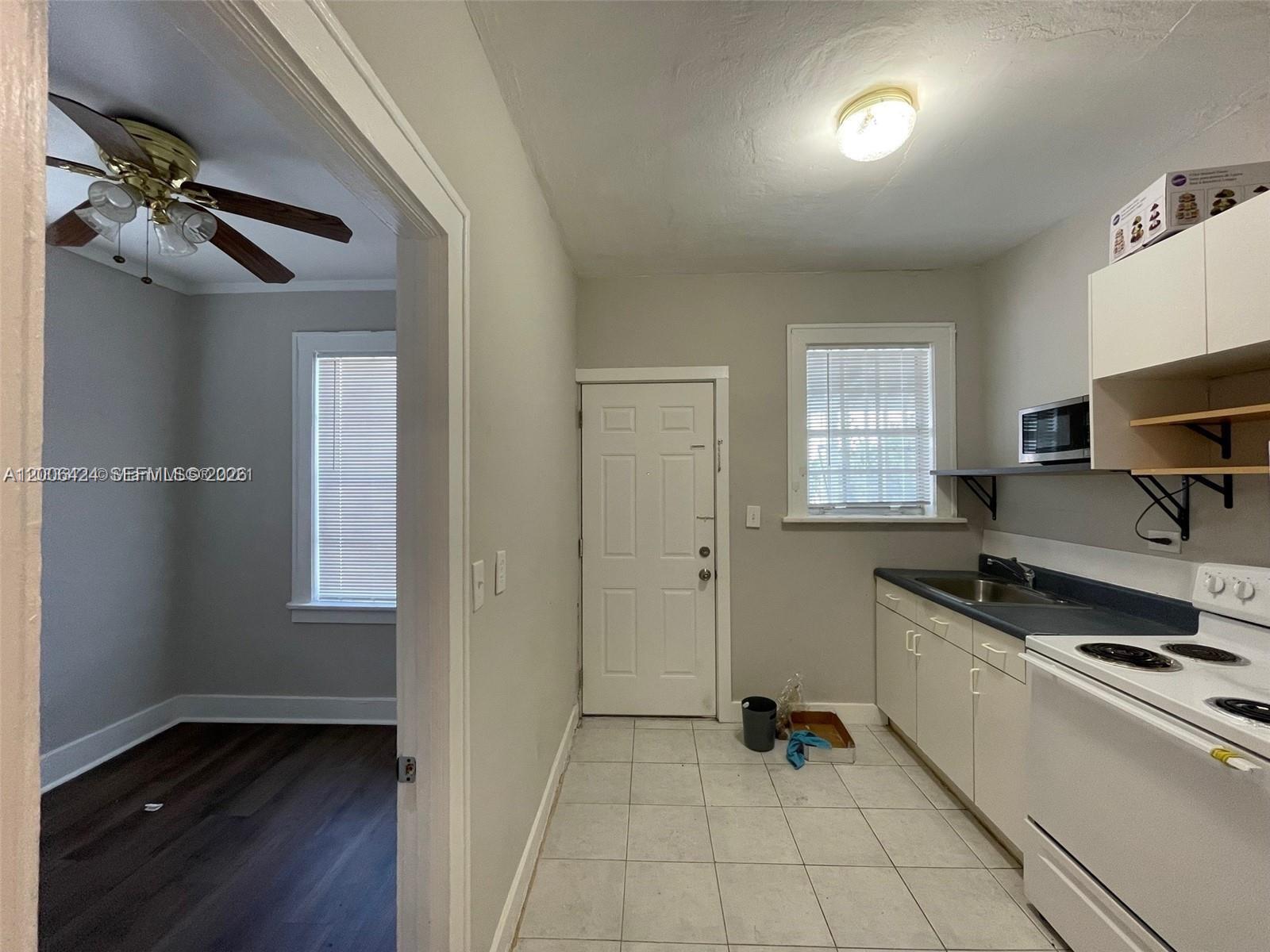 3364 Southwest 2nd Street, Unit 4 Miami, FL 33135 - Photo 10 of 14 a kitchen with stainless steel appliances granite countertop a sink and wooden cabinets