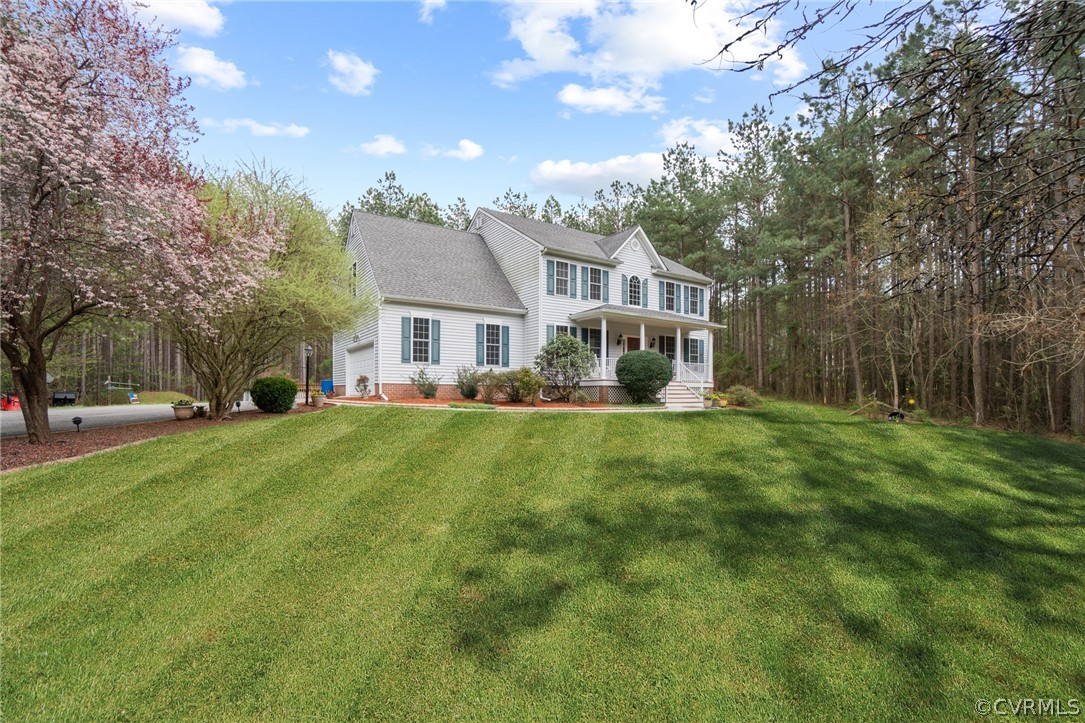 a front view of a house with a yard and trees