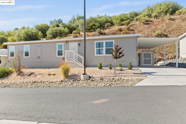 a front view of a house with a yard and potted plants