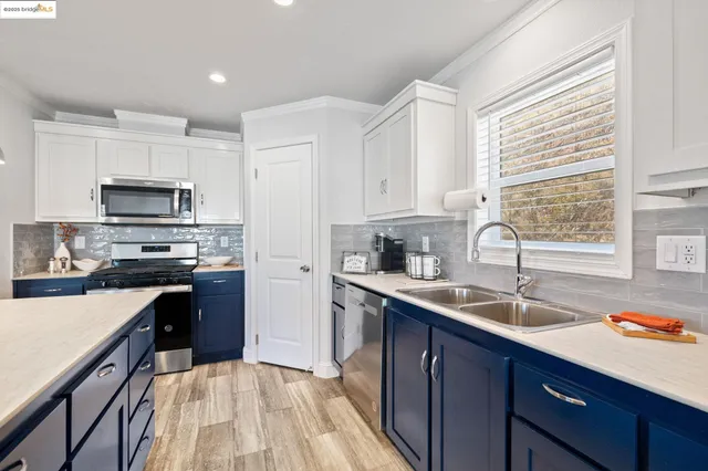 a kitchen with a sink a counter top space stainless steel appliances and a window