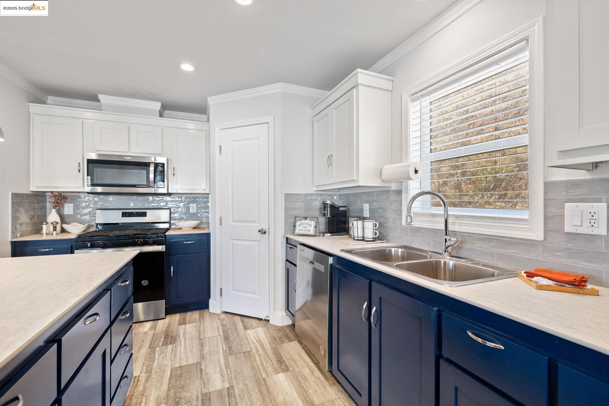 18717 Mill Villa Road, Unit 547 Jamestown, CA 95327 - Photo 7 of 20 a kitchen with a sink a counter top space stainless steel appliances and a window