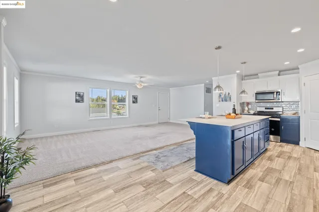 a kitchen with stainless steel appliances kitchen island wooden cabinets and entryway