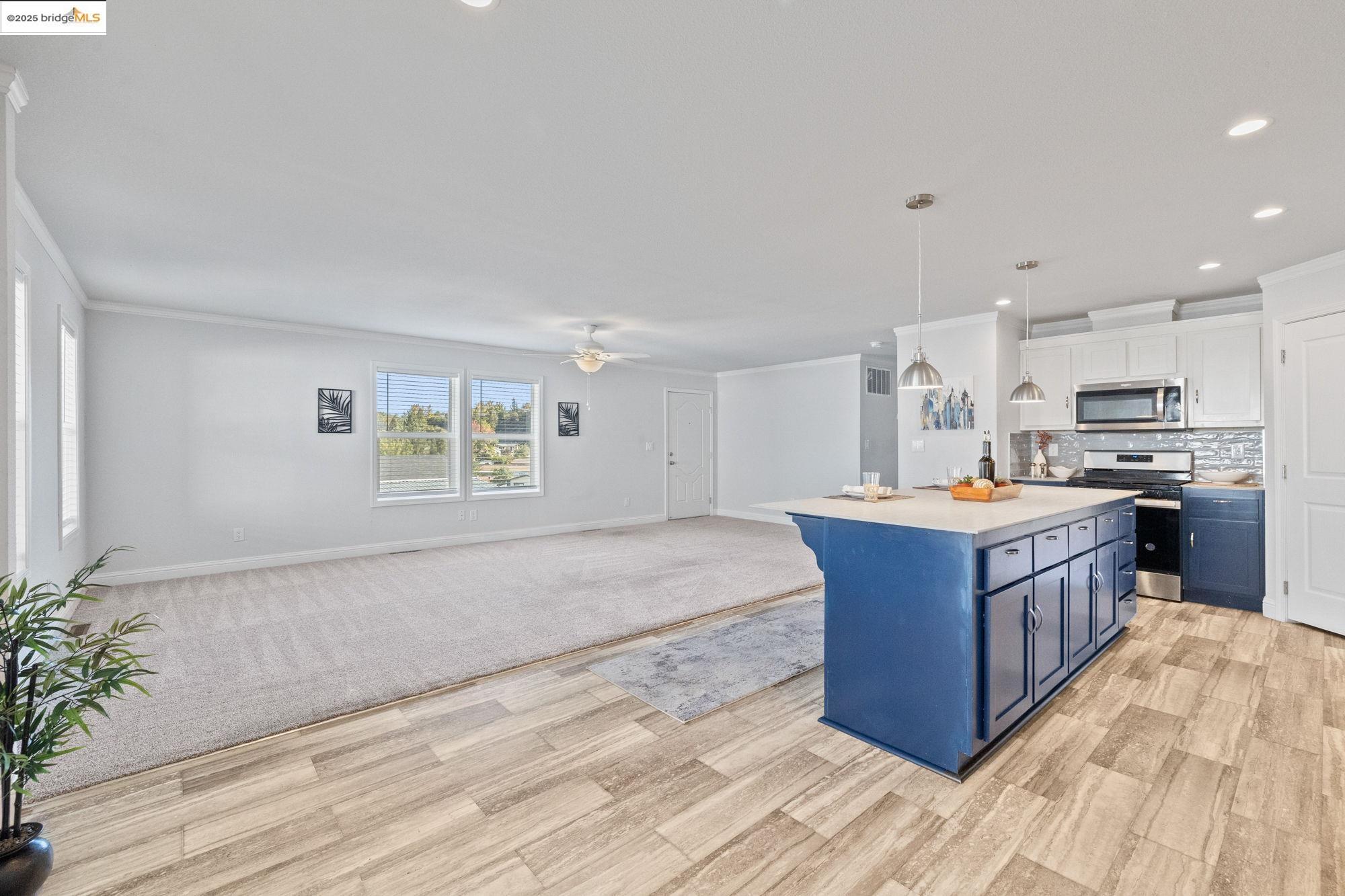 18717 Mill Villa Road, Unit 547 Jamestown, CA 95327 - Photo 9 of 20 a kitchen with stainless steel appliances kitchen island wooden cabinets and entryway
