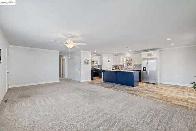 a view of kitchen and kitchen with a sink wooden cabinets