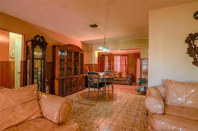 a living room with furniture a chandelier and a dining table