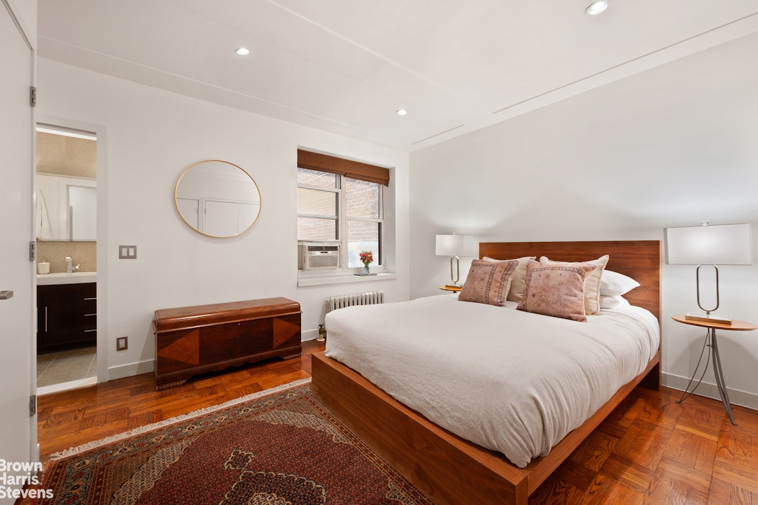 135 East 39th Street, Unit 1CD Manhattan, NY 10016 - Photo 6 of 11 a bedroom with a bed and a chandelier