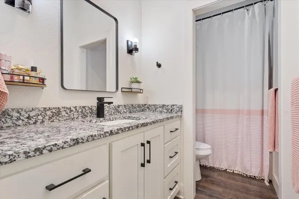 a bathroom with a granite countertop sink and a mirror
