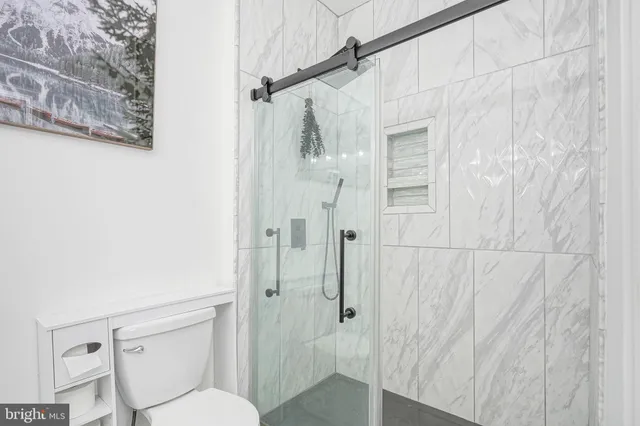 a bathroom with a toilet and a shower