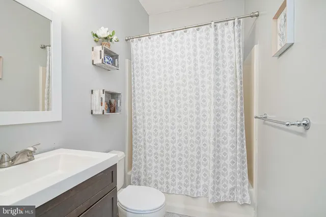 a bathroom with a sink a toilet and shower curtain