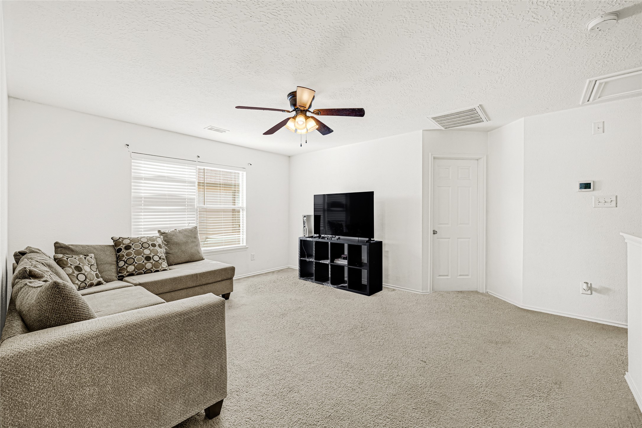 2911 Aspen Fair Trail Spring, TX 77389 - Photo 14 of 24 a living room with furniture a ceiling fan and a flat screen tv