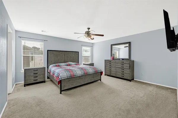 a spacious bedroom with a bed a fireplace and a chandelier