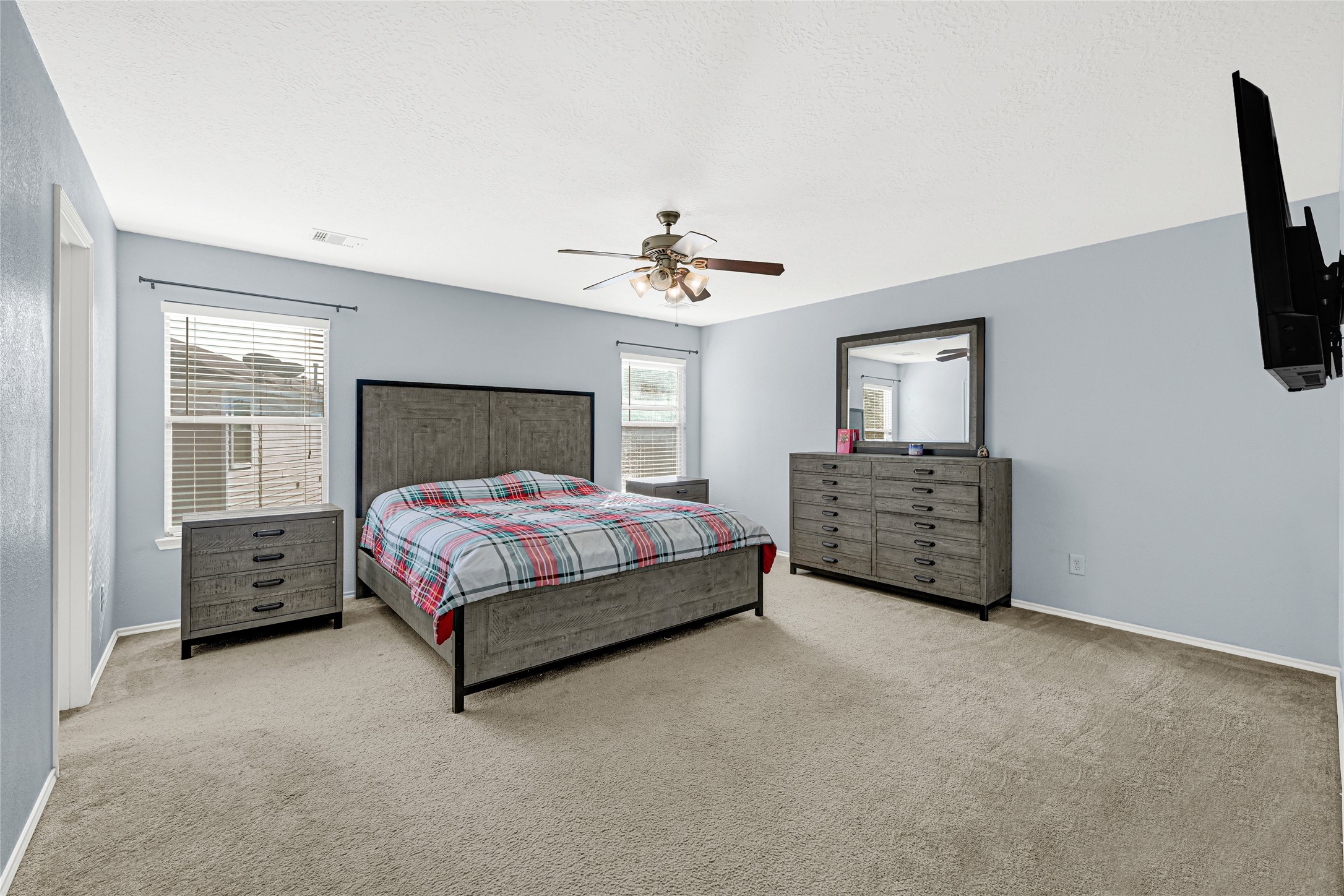 2911 Aspen Fair Trail Spring, TX 77389 - Photo 15 of 24 a spacious bedroom with a bed a fireplace and a chandelier