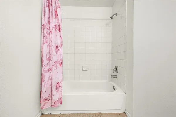 a bathroom with a bathtub and shower