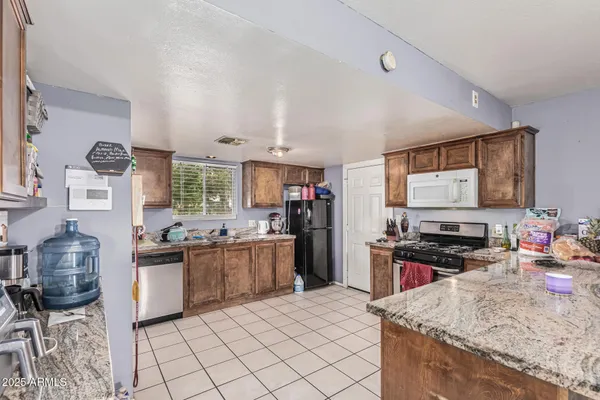 a kitchen with stainless steel appliances a stove a sink dishwasher and cabinets with wooden floor