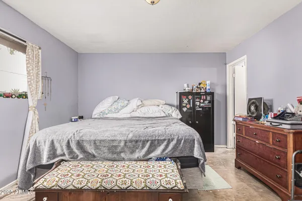 a large bedroom with a bed and a dresser