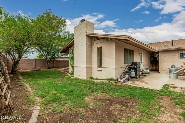 a backyard of a house with barbeque oven table and chairs