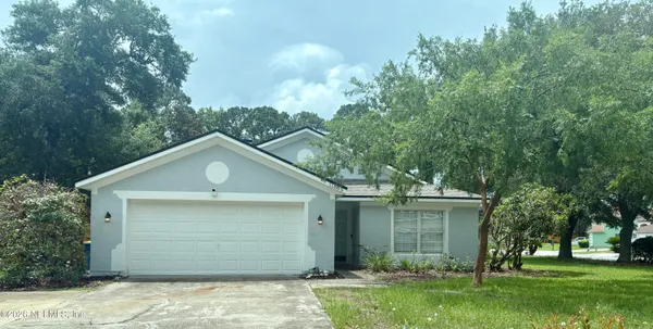a front view of house with yard and trees