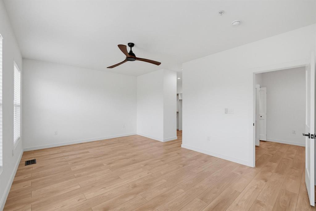 508 South O Connor Road Irving, TX 75060 - Photo 13 of 21 Spacious room featuring wood-finish flooring, crisp white walls, and a contemporary ceiling fan