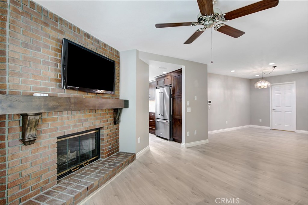 2166 Malati Circle Upland, CA 91784 - Photo 11 of 40 a view of a livingroom with a fireplace a ceiling fan and wooden floor
