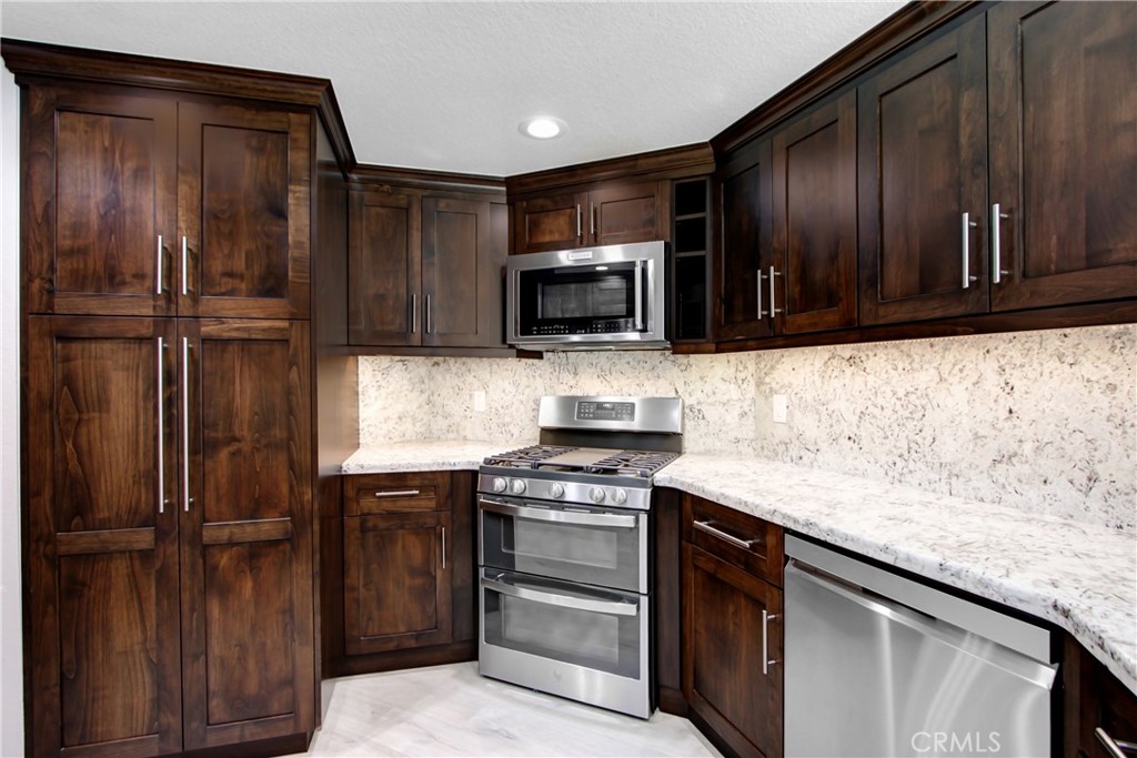 2166 Malati Circle Upland, CA 91784 - Photo 14 of 40 a kitchen with granite countertop wooden cabinets and stainless steel appliances
