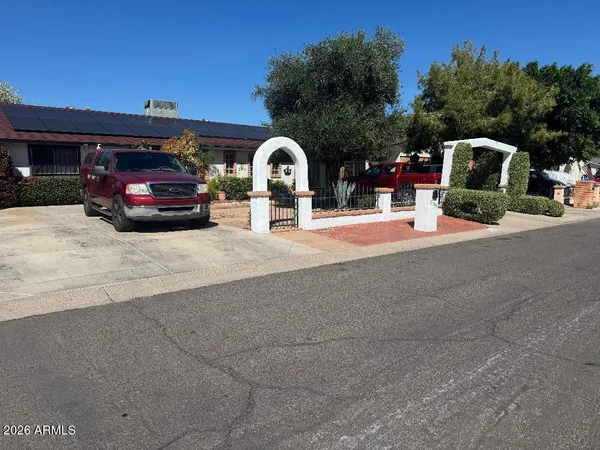 a front view of a house with cars parked